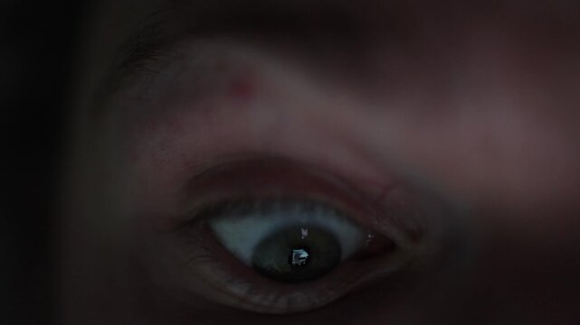 Watches all these videos at night wide open eye reflecting phone screen endless scrolling surprise and digital overload concept