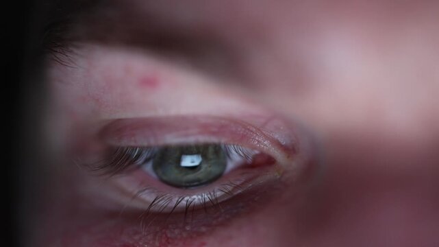 Extreme close up of tired eye lit by screen glow late night phone use digital addiction insomnia concept fatigue and blue light strain