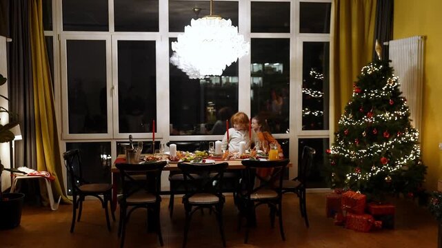 Brother and sister run and sit at the table