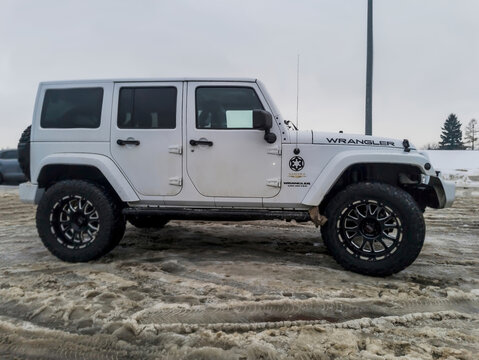 Polska, Ostrowiec Świętokrzyski, 15 stycznia 2026, 14:51. Biały Jeep Wrangler Sahara (kultowy samoch&oacute;d terenowy) w zimowy dzień zaparkowany na ośnieżonym parkingu. Pojazd ma duże opony terenowe 