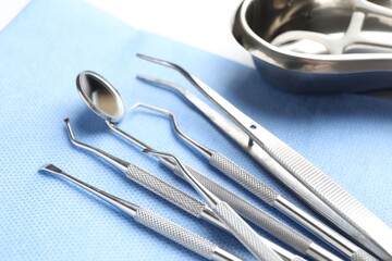 Many different dental tools and medical napkin on white table, closeup