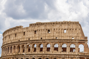 Obraz premium Famous tourist attraction of historic Colosseum amphitheatre with ancient stone arches in Rome Italy