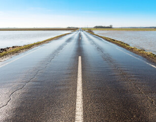 &ldquo;Flood ahead&rdquo; warning sign on rural road with fog and flooded roadway