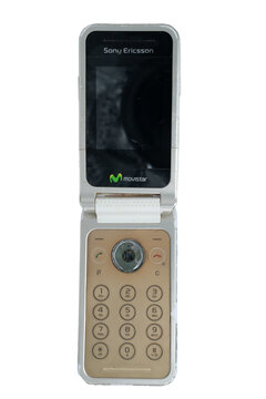 Madrid, spain 20 february 2026. Vintage sony ericsson flip phone standing open, showing screen and keypad on a white background