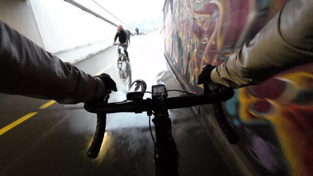 POV shot of cyclist riding through bicycle underpass shared with pedestrians and cyclists, everyday mobility concept