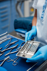 Surgical tools are organized on a tray in a medical setting during a procedure preparation time