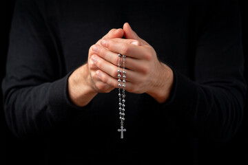Holding a silver rosary with gentle faith in quiet reflection