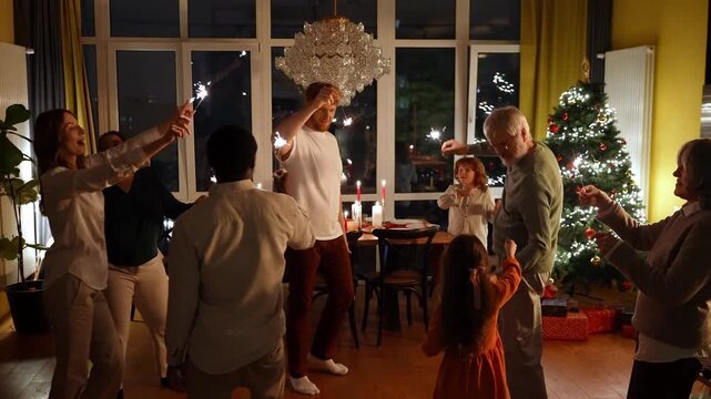 Family and guests holding sparklers and dancing in a circle