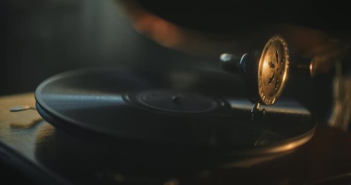 Glowing golden needle on turntable of gramophone - closeup shot in dark room