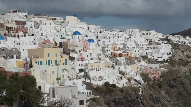 Oia, &Omicron;ί&alpha;, Santorini, Greece. Traditional Cycladic architecture with iconic white houses and a blue domed church set against the caldera cliffs.
