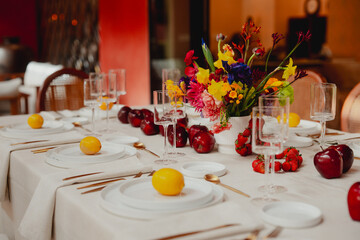 Table decorated for celebration with lemons, apples, fresh flowers