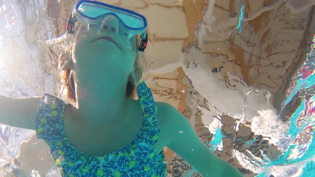 Young swimmer explores vibrant underwater world with joyful curiosity