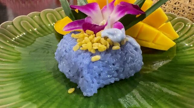 Pouring Sauce on a Plate of Mango and Purple Sticky Rice