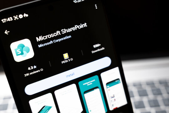 Warsaw, Poland - Feb 24, 2026: Close-up of a mobile screen displaying Microsoft SharePoint app information, showcasing its features, rating, and download stats against a dark backdrop.