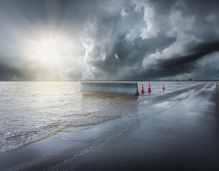 Flooded road with construction barrier and cones during storm and dramatic light
