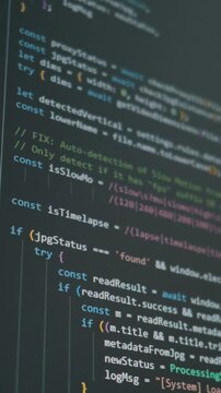Vertical close-up screen displays scrolling JavaScript syntax for AI development. Concept of vibe coding, machine learning automation, and future tech workflow.
