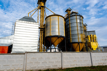 Obraz premium A large modern plant for the storage and processing of grain crops. Agro-processing manufacturing plant for processing drying cleaning and storage of agricultural products. Export of grain by railway