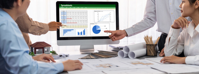 Group of interior architect designer discussing together on blueprint and laptop screen display...