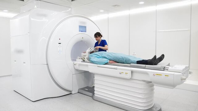 Medical professional prepares the patient and checks safety before MRI scan. Modern medical technologies concept.
