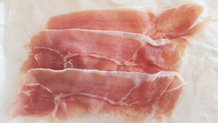thin slices of Spanish hamon on a light background.