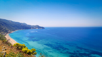 Fototapeta premium Panoramic View of Turquoise Mediterranean Coastline with Mountain Landscape and Crystal Clear Sea. Aerial-style scenic panorama of a serene summer beach with vibrant blue water and untouched natural s