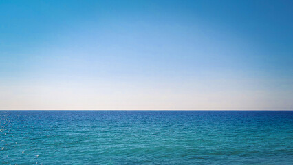 Obraz premium Panoramic View of Turquoise Mediterranean Coastline with Mountain Landscape and Crystal Clear Sea. Aerial-style scenic panorama of a serene summer beach with vibrant blue water and untouched natural s