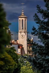 Obraz premium The San Lorenzo clock tower lit against dark dramatic clouds in Pamplona, Spain