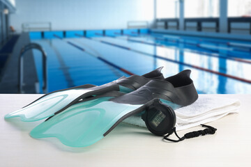 Swimming lesson. Flippers, stopwatch and towel by swimming pool © New Africa
