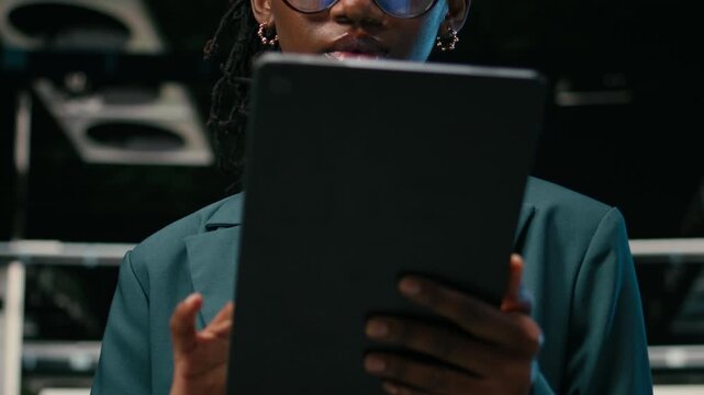 Close up of smiling data center female engineer pleased after futureproofing network downtimes. Portrait of cheerful woman satisfied after increasing server farm cybersecurity with tablet, camera A