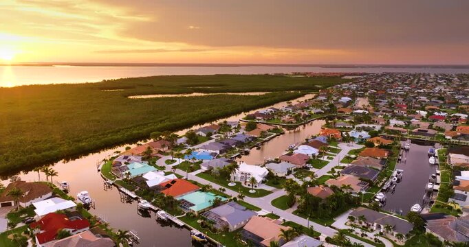 Evening light over Florida waterfront community. Expensive homes and luxury mansions illuminated by sundown sky.