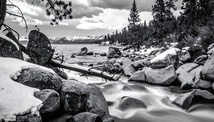 Fototapeta premium A serene winter landscape with a stream flowing through rocks and trees