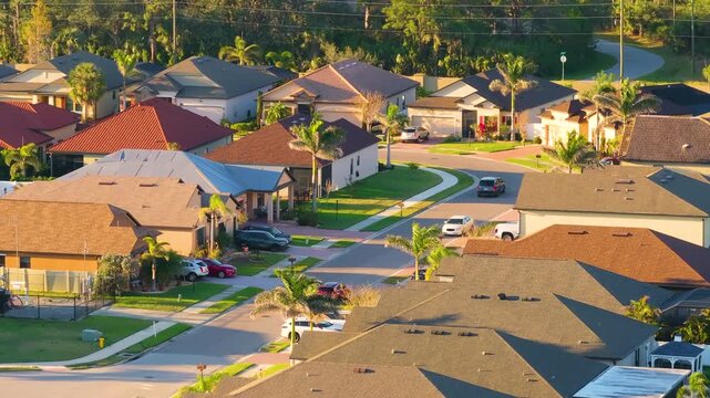 Gated community with expensive houses between green palm trees in southwest Florida. Premium housing development in the USA.