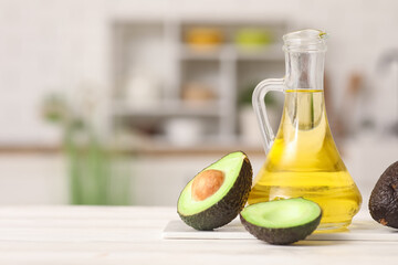 Obraz premium Jug of fresh avocado oil on white wooden table in kitchen