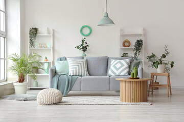 Naklejka premium Comfortable sofa and coffee table in interior of living room