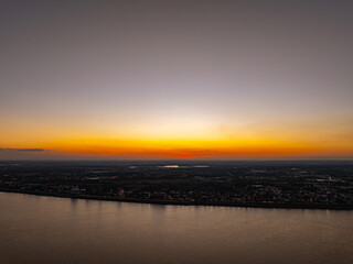 Obraz premium Aerial view of The Cost of Burning Crops Beneath a Golden Sun. As the sun sets, smoke from agricultural burning blankets the horizon, transforming natural beauty into a quiet warning of pollution.