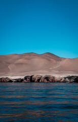 Desert mountains meeting the blue ocean coast