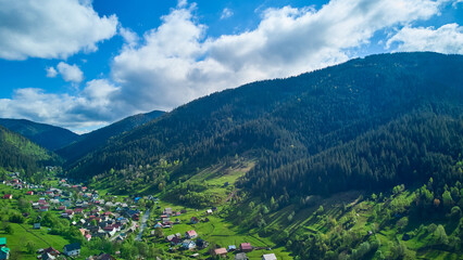 Obraz premium a high view on city near green mountains with blue sky