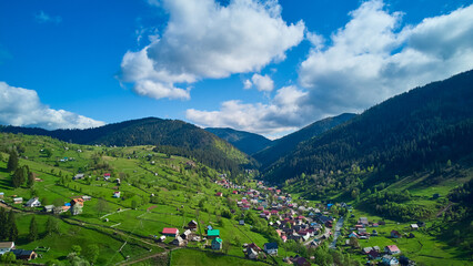 a high view on city near green mountains with blue sky