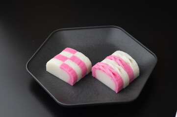 お皿にのっている紅白の蒲鉾