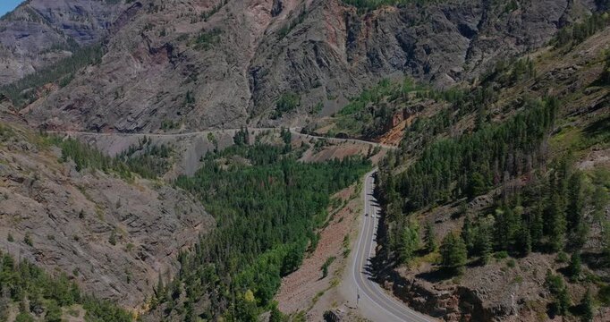Elevated aerial of serpentine mountain road across steep alpine Colorado terrain, Million Dollay Highway Colorado USA
