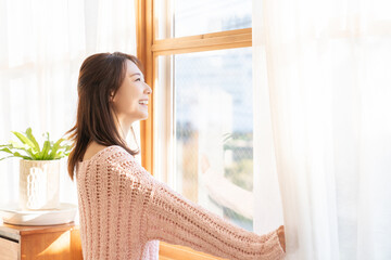 カーテンを開ける女性