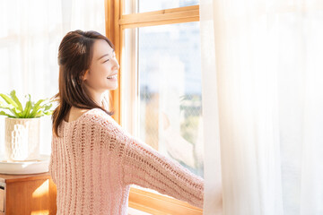 カーテンを開ける女性