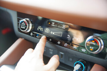 カーエアコンの温度調整をする男性