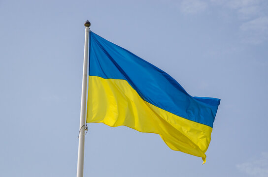 Blue and yellow Ukrainian flag in the blue sky