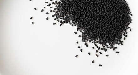 Black sesame seeds are scattered organically across a bright white background, creating a minimalist and healthy food ingredient flat lay with ample copy space.