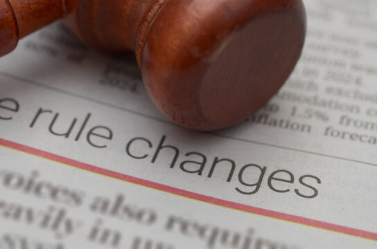 Wooden Gavel Resting on Newspaper Featuring Bold 'Rule Changes' Headline