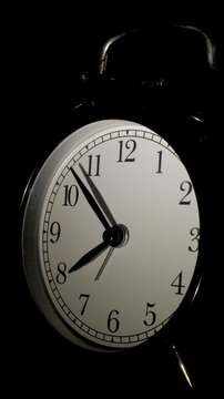 Vertical time lapse of a clock time passing over a day to night.