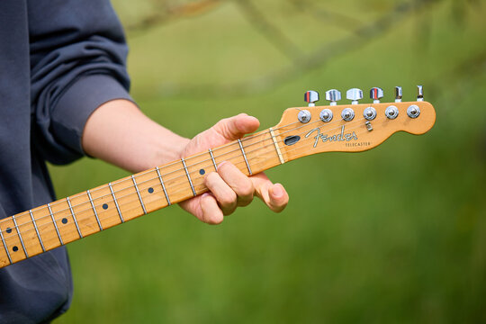 Caucasian male adult playing electric guitar outdoors close-up. June 21, 2025 Edinet Moldova