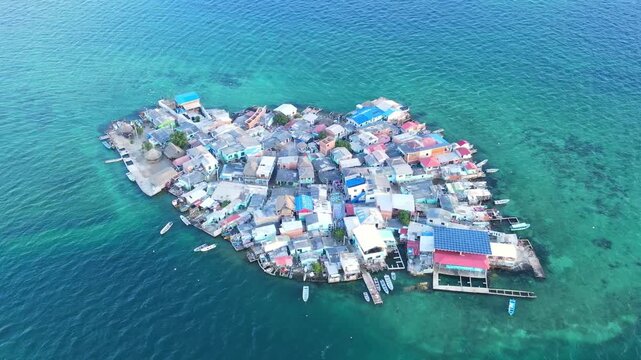 Aerial view of colorful houses on a small island surrounded by blue waters.