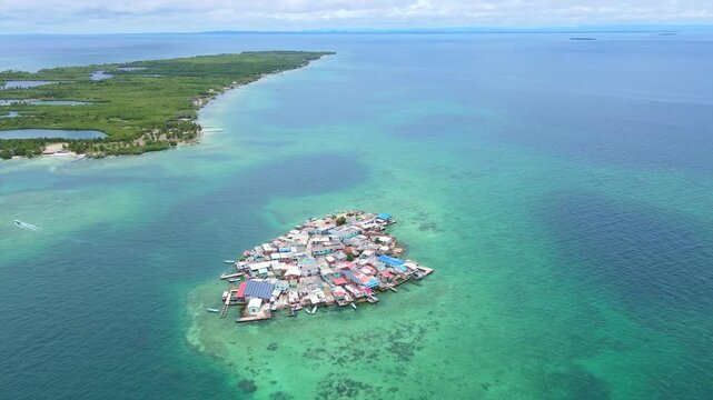 Vibrant homes dot the small island of Santa Cruz del Islote against a backdrop of turquoise waters and lush green islands.